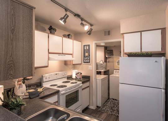 Apartments Ahwatukee, AZ - Pacific Bay Club - Kitchen with Wood-Style Plank Flooring, White Appliances, and White Cabinets with Wood Trimming