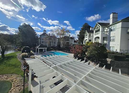 A large white building with a pool in front of it.