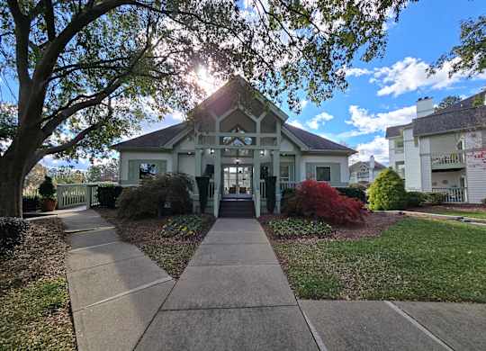 A house with a white picket fence and a tree in front.