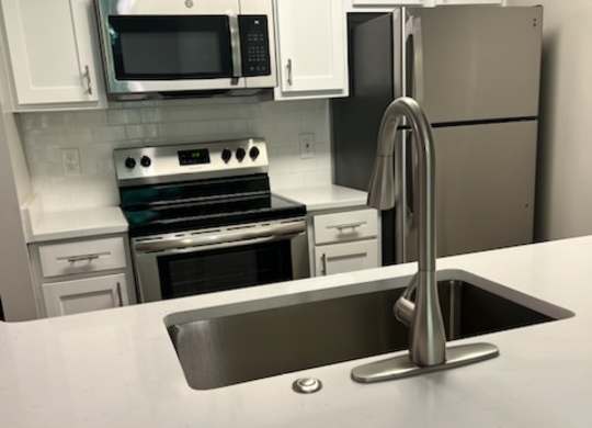 a kitchen with a sink a stove and a microwave