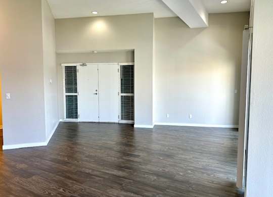 an empty living room with white walls and wood floors