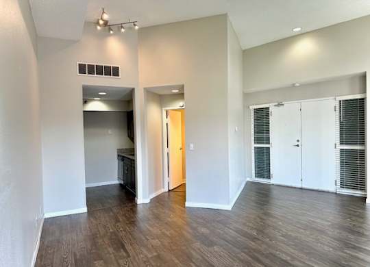 an empty living room with white walls and wood floors