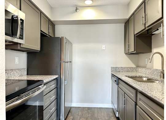 a kitchen with granite counter tops and stainless steel appliances