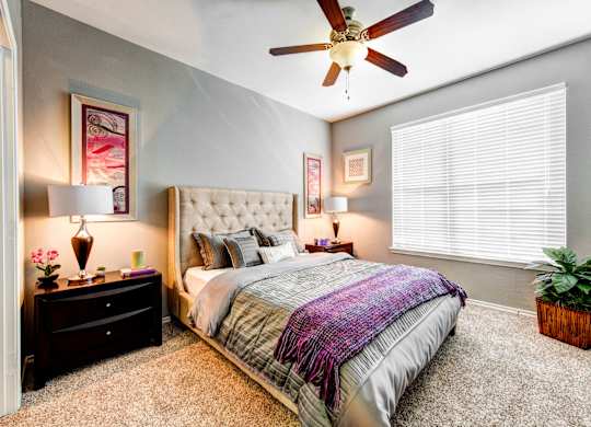 bedroom with large window and ceiling fan