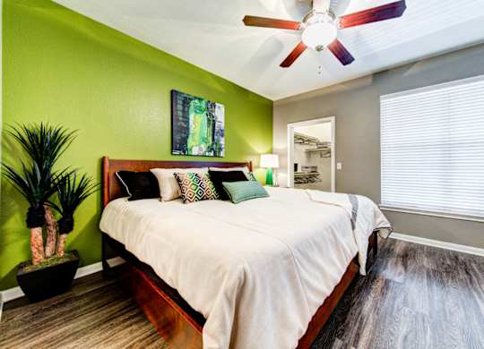 bedroom with large window and ceiling fan