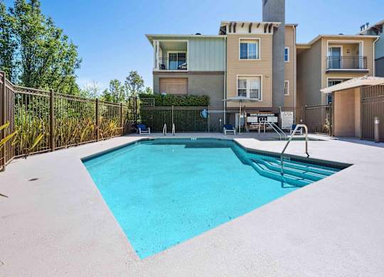 Apartments in Walnut Creek for Rent - Ivy Hill - An exterior shot of the swimming pool featuring a spa and blue lounge chairs