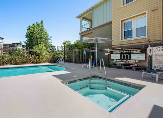 Apartments in Walnut Creek, CA- Ivy Hill- Sparkling Pool and Spa with Blue Lounge Chairs and View of Apartment Complex