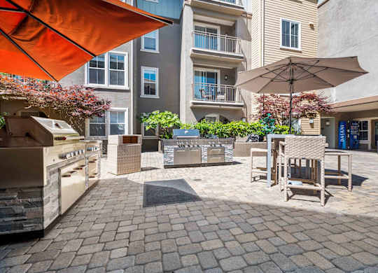 Apartments for Rent in Walnut Creek, CA - Ivy Hill - Grilling Area with Two Grilling Stations, Umbrellas, Tables and Chairs, and a Vending Machine.