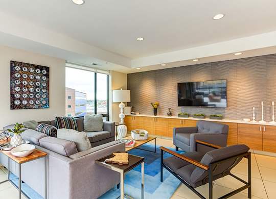 A living room with a grey couch, a coffee table, and a television.