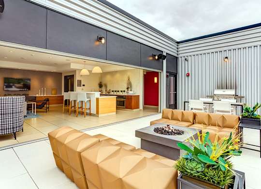 A modern living room with a large sofa and a dining area in the background.