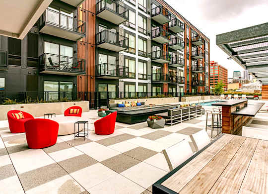 an outdoor patio with tables and chairs at a building with a pool