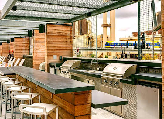 a bar with a row of bar stools and stainless steel appliances
