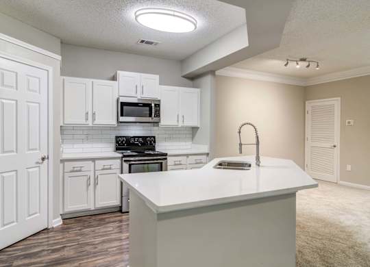 Woodstock, GA Apartments – Lea Woodstock – Luxury kitchen with quartz counter tops, white cabinets, stainless-steel appliances and hardwood floors