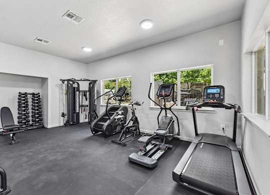 A spacious home gym with a variety of exercise equipment.