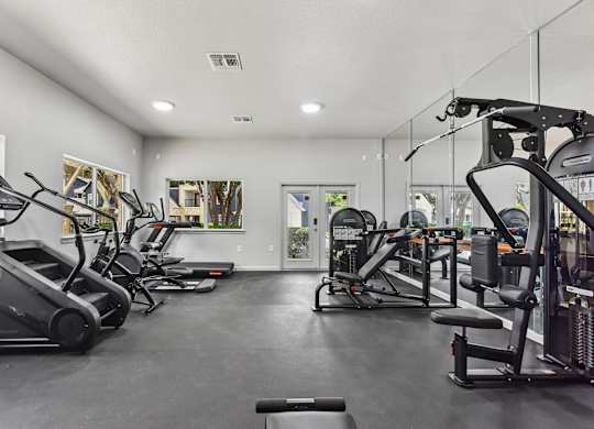 A spacious gym with treadmills, elliptical machines, and other exercise equipment.