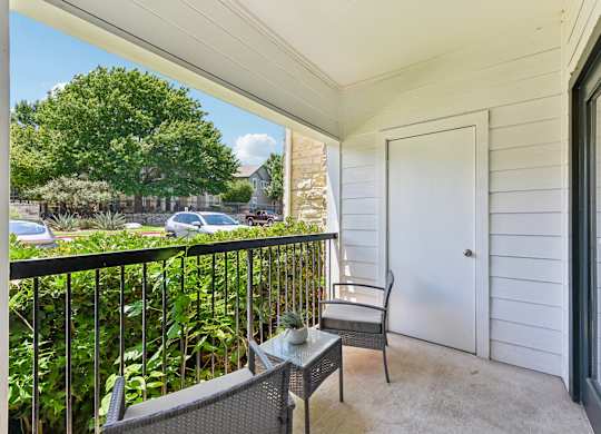 A balcony with a chair and table.