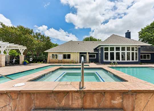 A house with a pool in front of it.