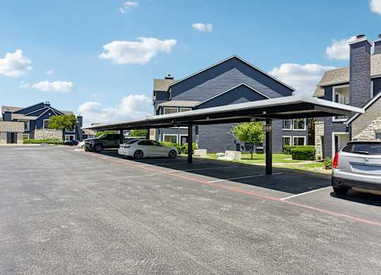 A parking lot with cars and a building in the background.