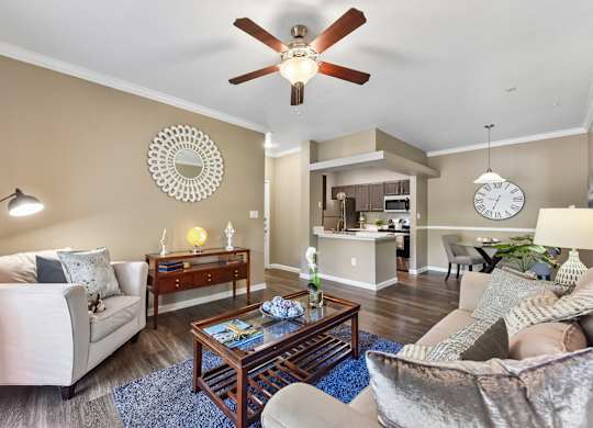 A living room with a white couch, a coffee table, and a ceiling fan.