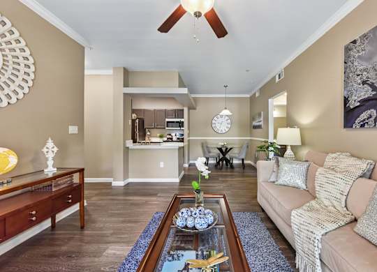 A living room with a couch, coffee table, and a ceiling fan.