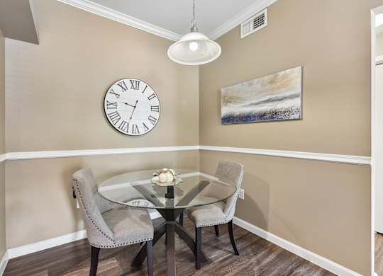 A dining room with a glass table and chairs.
