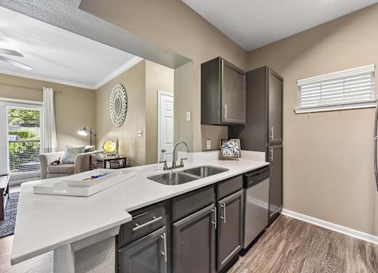 A kitchen with a white counter top and black cabinets.