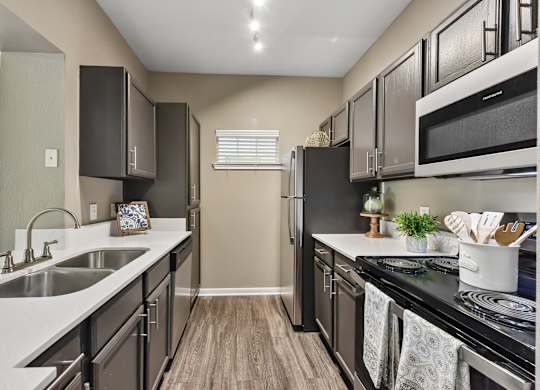 A kitchen with black cabinets and a white counter top.