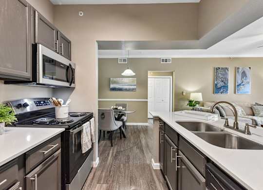 A kitchen with a black stove top oven and a black microwave.