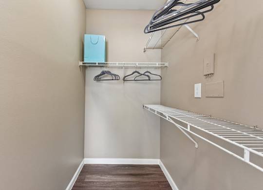 A small closet with a shelf and a hanger rack.