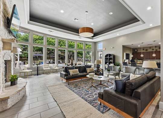 A modern living room with a stone fireplace and a large window.