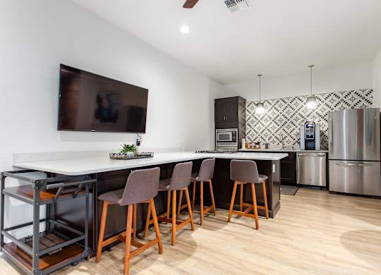 A kitchen with a white counter top and brown chairs.