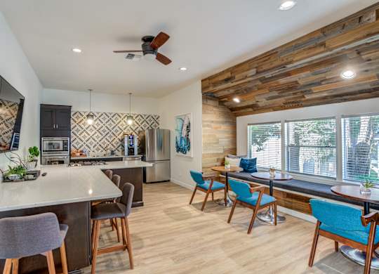 a kitchen and living room with a large window and a ceiling fan