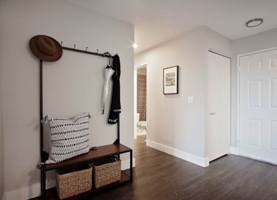 A room with a coat rack and a bench.