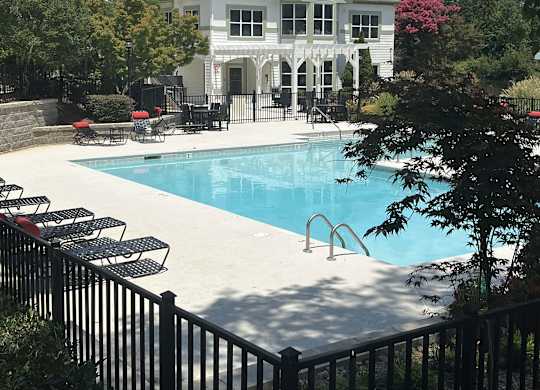 a swimming pool with a house in the background