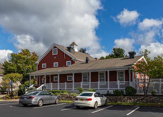 Orchards Apartments Marlborough ma apartment loft style apartments photo of clubhouse exterior with red siding and white rails next to parking lot