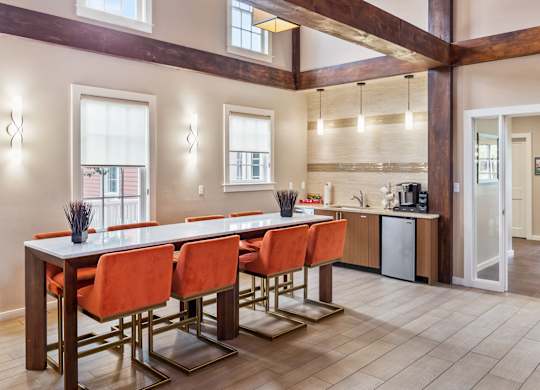 Orchards Apartments Marlborough ma apartment loft style apartments photo of clubhouse lounge with long bar table with bar stools and exposed beams in open floor plan with multiple windows