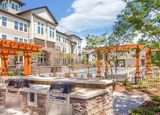 A sunny day at a residential area with a pool and a barbecue grill.