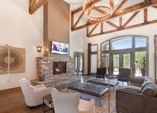 A modern living room with a stone fireplace and a large chandelier.