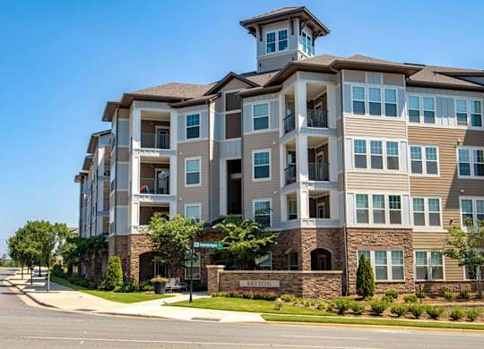 A large apartment building with a stone facade and balconies.