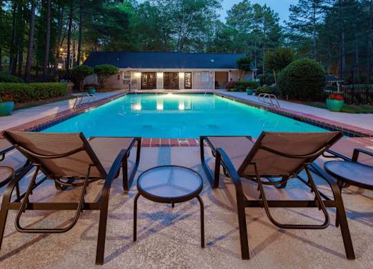 Pet-Friendly Apartments in Alpharetta, GA – Webb Bridge Crossing – swimming pool at dusk with patio chairs