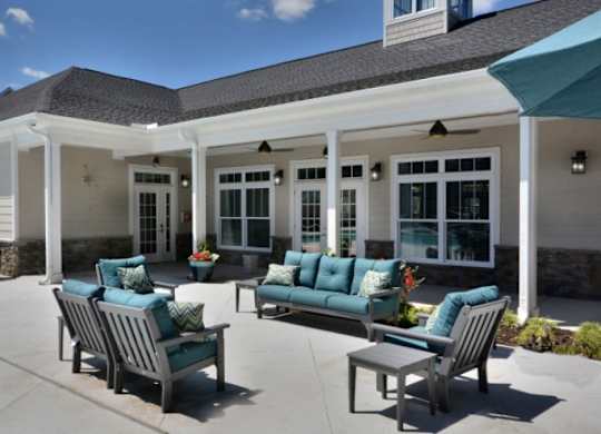 A patio with a couch, chairs and a table.