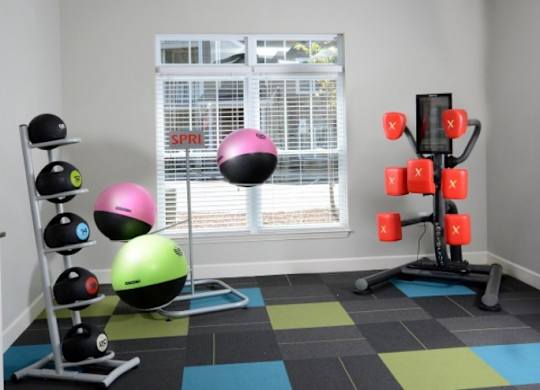 A room with a black and white checkered floor and a weight rack with red weights.