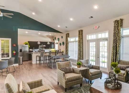 A living room with a variety of seating options and a dining area in the background.