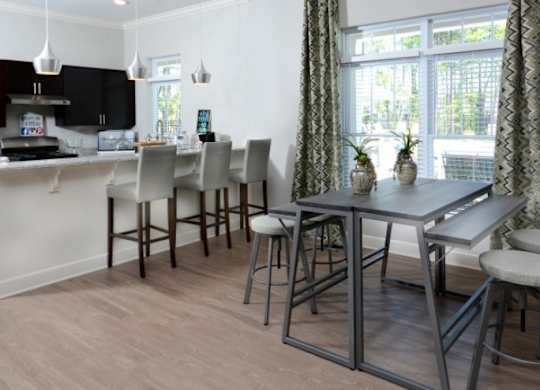 A kitchen with a table and chairs.