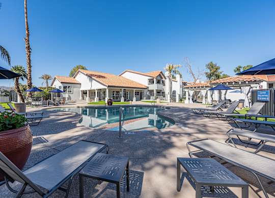 a pool with tables and chairs around it at the resort