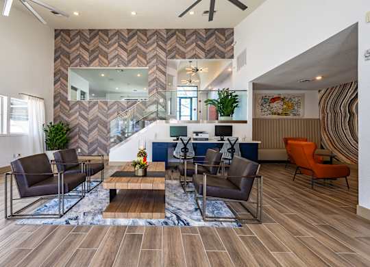 A living room with a chevron patterned wallpaper and a wooden floor.