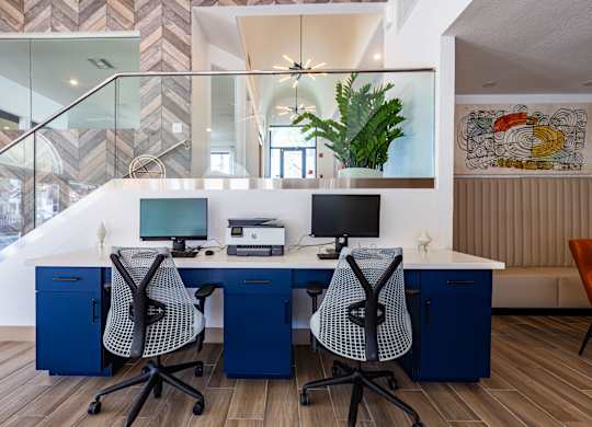 a home office with two desks and two computer monitors