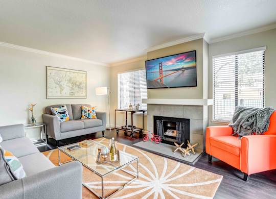 Apartments for Rent in Walnut Creek, CA - Park Lake at Walnut Creek - Furnished Living Room with a Cozy Fireplace, Distinctive Wood-Style Flooring, Two Large Windows, and Stylish Decor