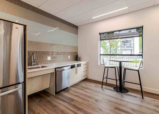 A kitchen with a refrigerator, sink, and dishwasher.