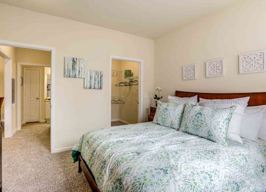 A bedroom with a bed, dresser, and mirror.